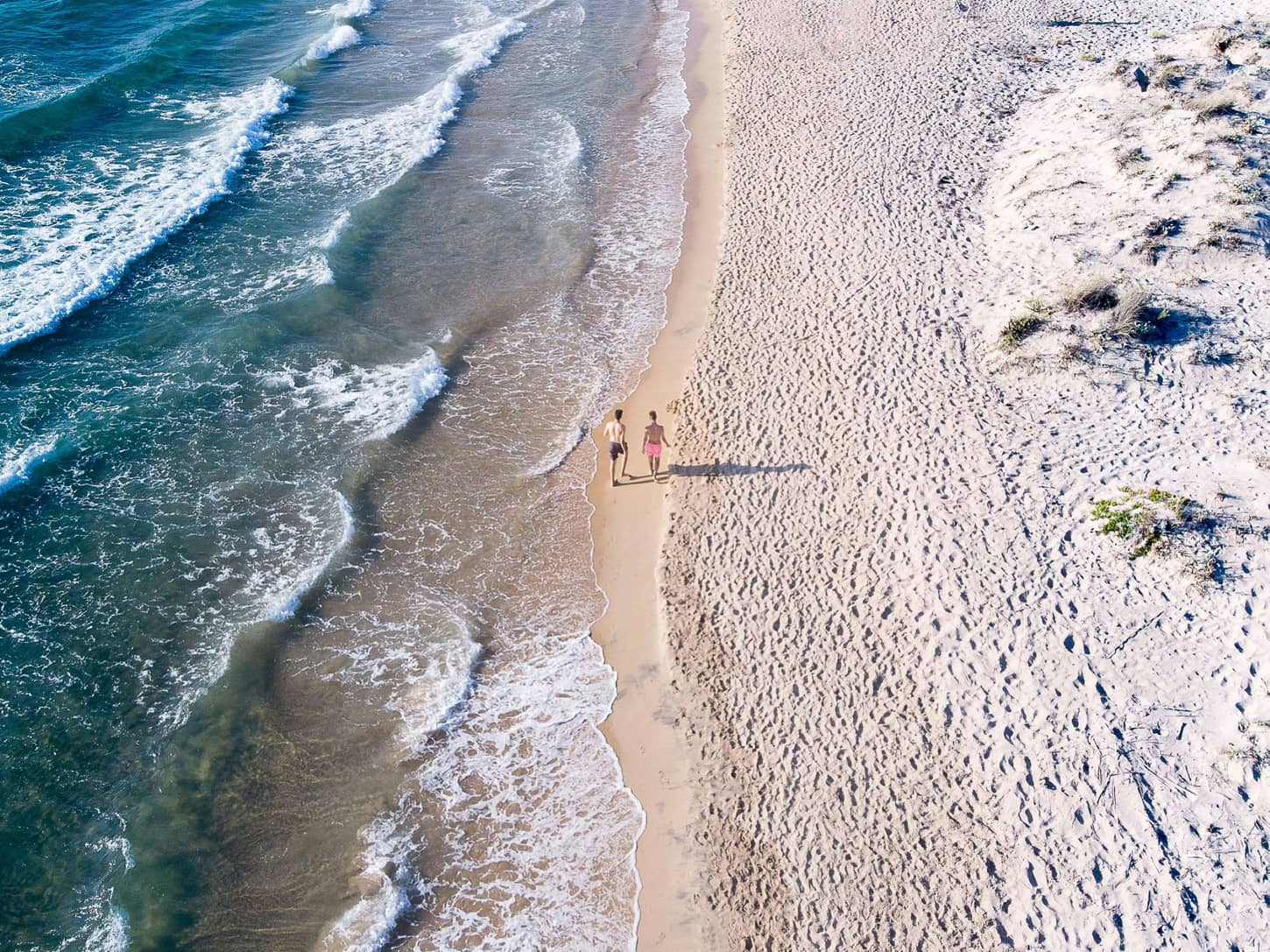 Couple marchant le long d'une plage, symbole de sérénité et de protection offerte par les garanties de prévoyance adossées au PER