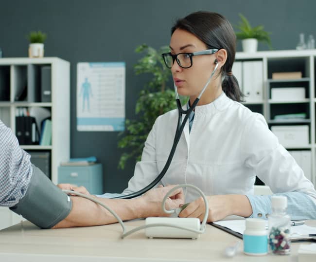 PER pour travailleur non salarié (TNS) : professionnelle de santé auscultant un patient dans son cabinet