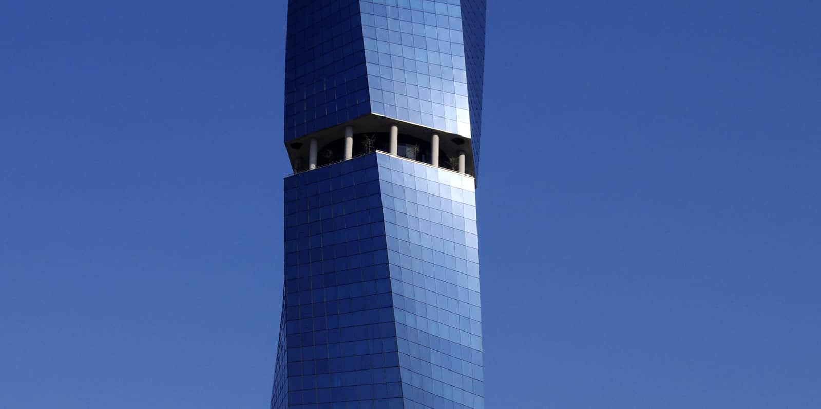 Tour de verre moderne sous un ciel bleu, symbole de transparence et de protection des données