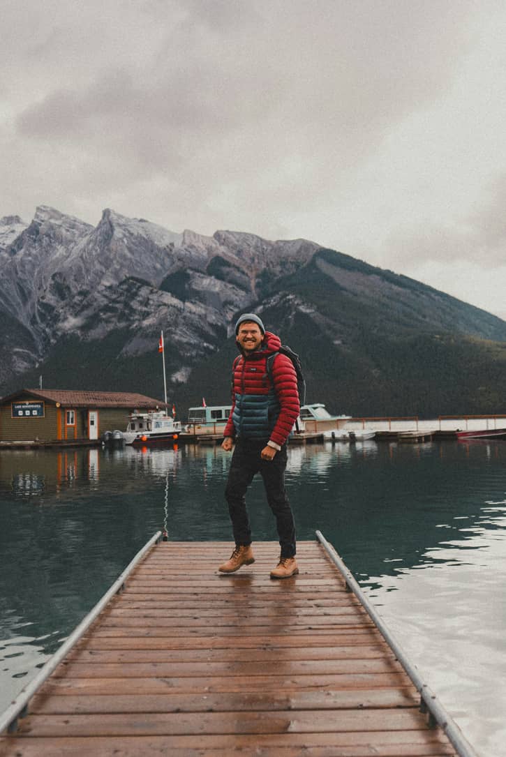 Randonneur souriant sur un ponton face à un lac de montagne, symbole d'un parcours d'épargne retraite long terme avec le PER Vie Plus PERtinence